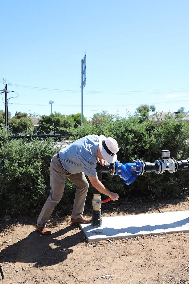 Mayor Kris Hanna turns the valve at Flinders University