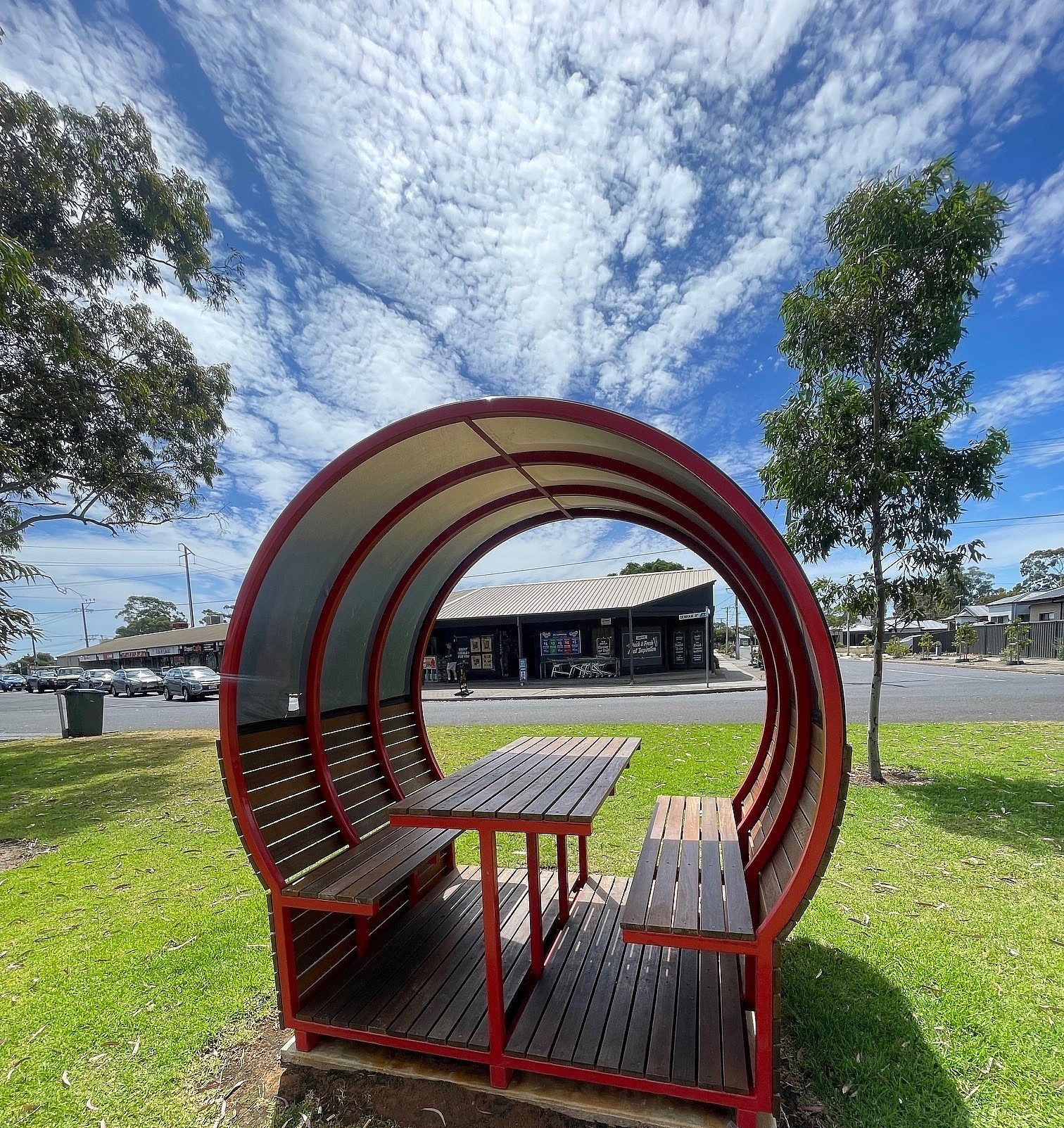 Back side of shaded bench which shows kiosk